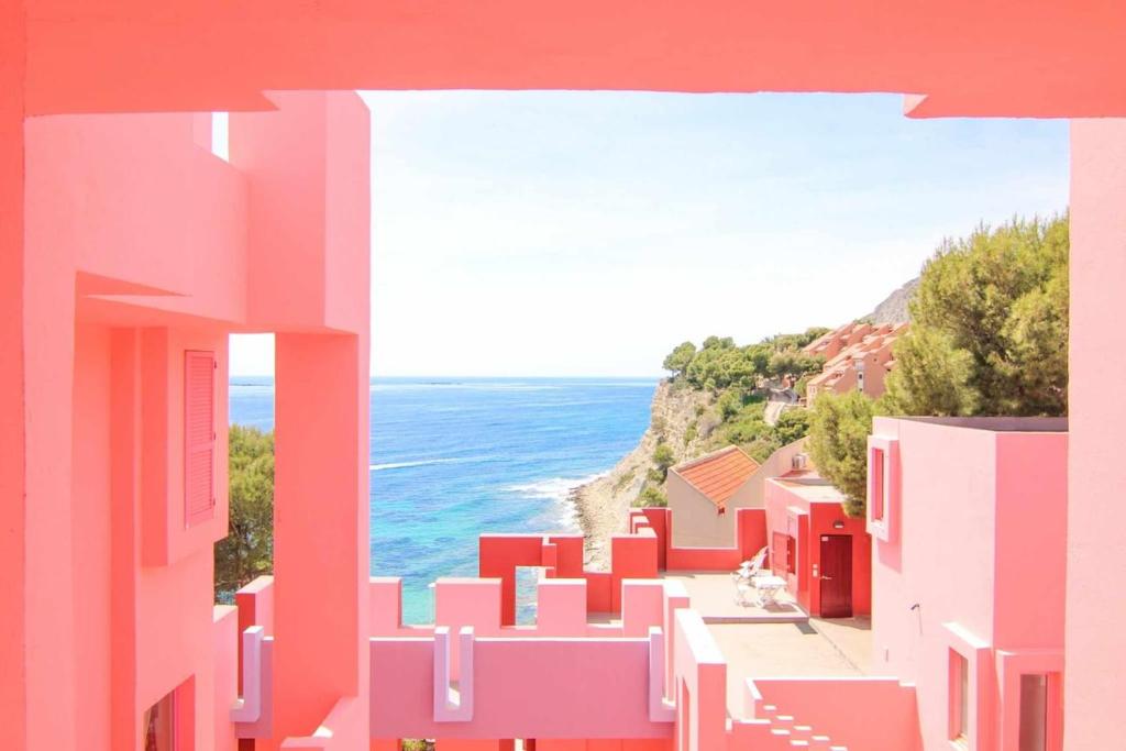 a view of a street with pink buildings and the ocean at Apartment with beautiful views - Muralla0218 in Calpe