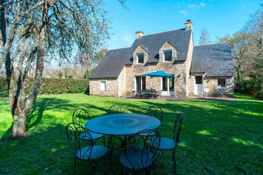 une table et des chaises devant une maison dans l'établissement Kerlavarec - Belle maison avec grand jardin, à Locmariaquer