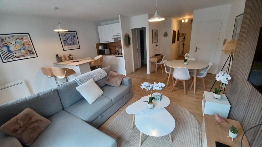 un salon avec un canapé bleu et une table dans l'établissement Le Petit Cozy - T2 en centre-ville, à Poitiers