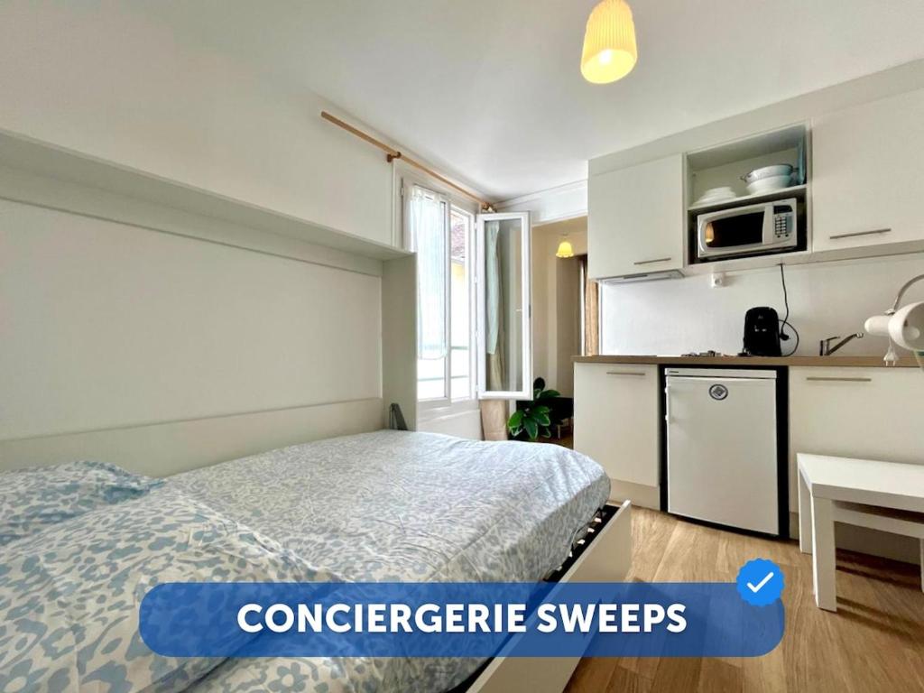 une petite chambre avec un lit et une cuisine dans l'établissement Le Studio des Sablons-2 pers-150m place du marche, à Fontainebleau