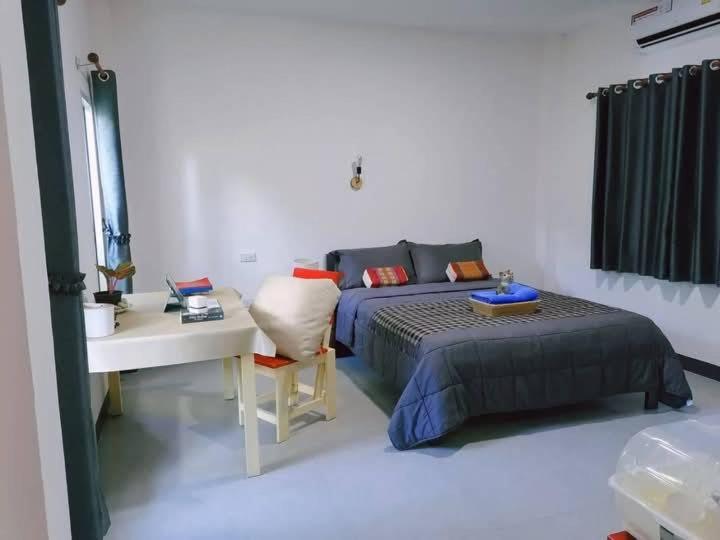 ホアヒンにあるBaan Mae Num HuaHin 102 บ้านแม่นุ่มのベッドルーム1室(ベッド1台、デスク、ベッド1台、テーブル付)
