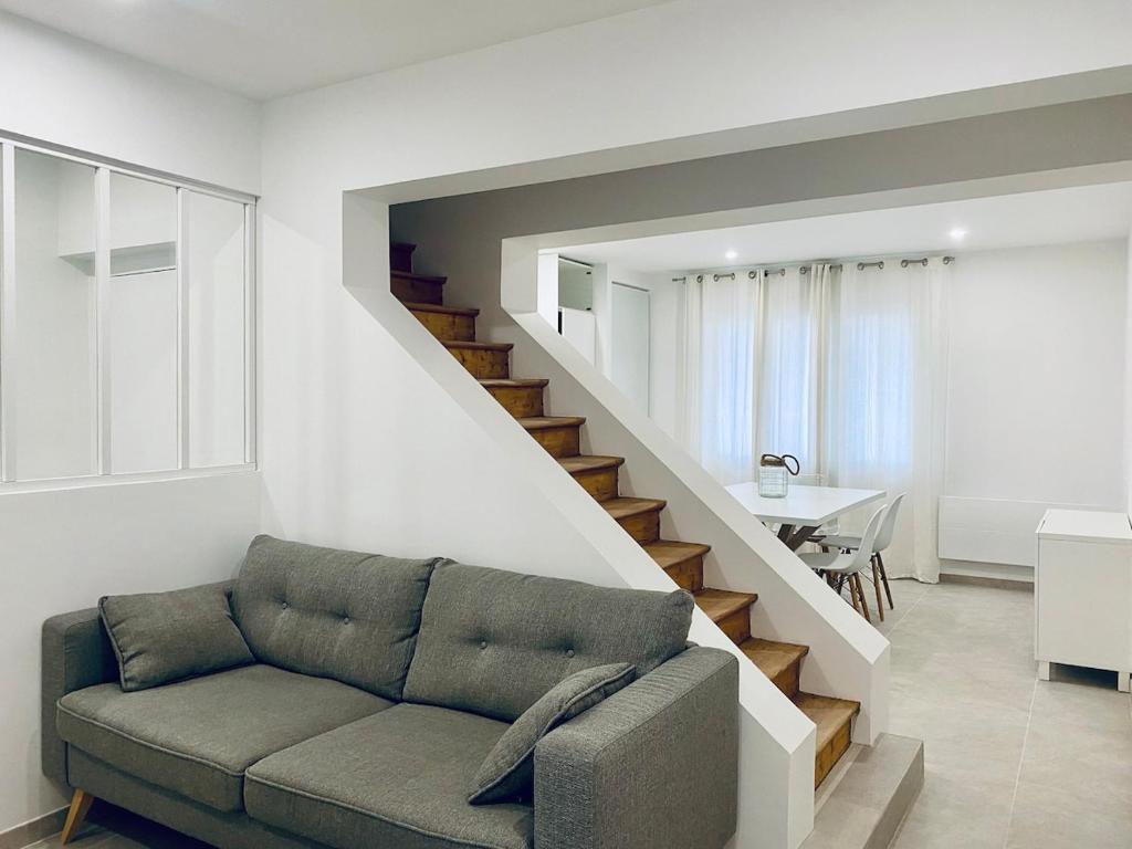 un salon avec un canapé et un escalier dans l'établissement Spacious apartment near Disneyland & GDC, à Annet-sur-Marne