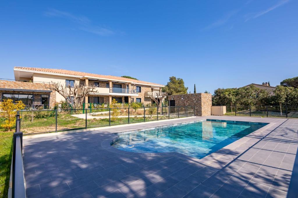 une piscine devant une maison dans l'établissement Appartement Sainte-Maxime - Welkeys, à Sainte-Maxime
