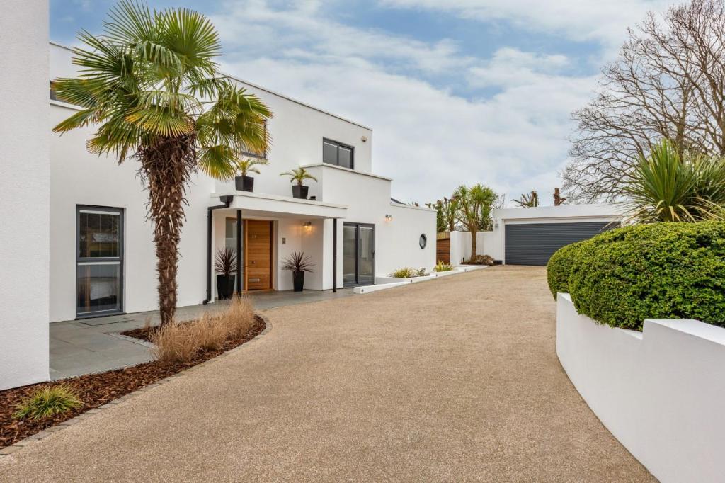 a white house with a palm tree in the driveway at The Crewhouse in Hamble