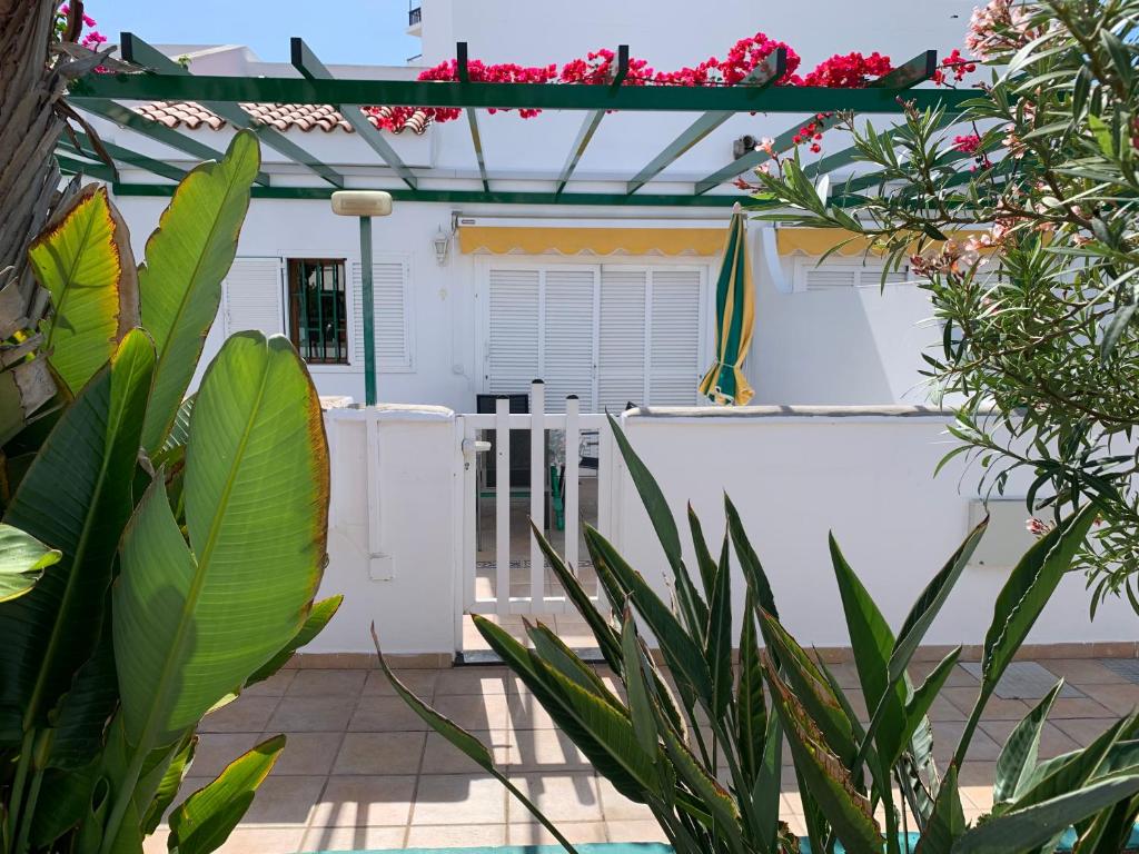 a white house with a fence and plants at Felicidad in Playa del Ingles