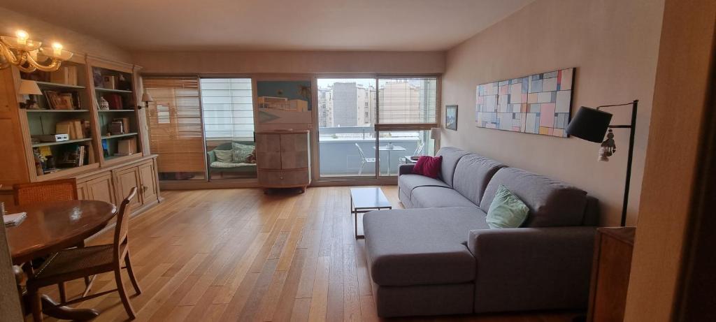 un salon avec un canapé et une table dans l'établissement Appartement chaleureux au cours du 15eme, à Paris