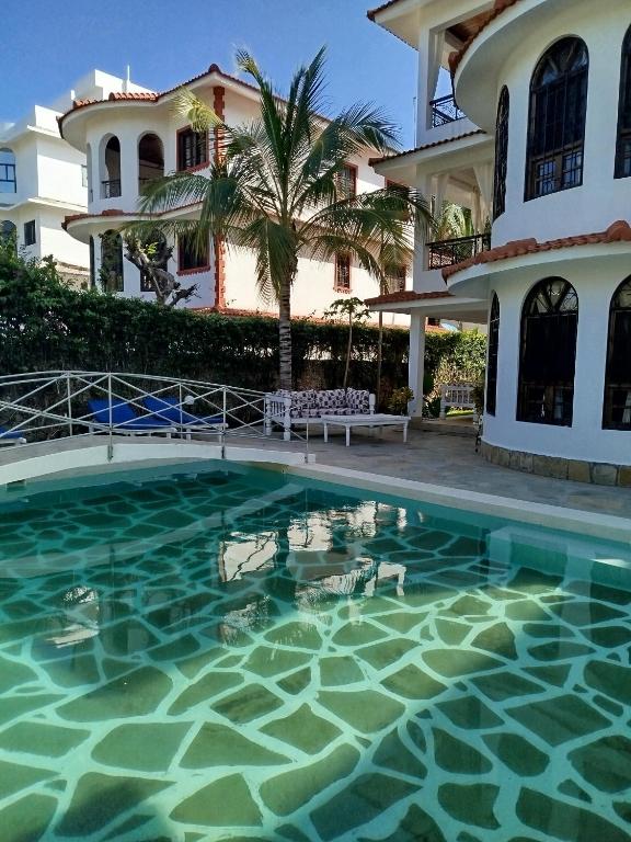 a swimming pool in front of a house at J and R Villa, Watamu in Watamu
