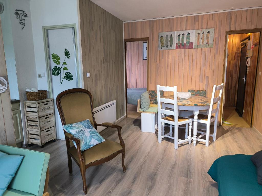un salon avec une table et des chaises dans l'établissement Appartement vert tendre face à la montagne, à Luchon