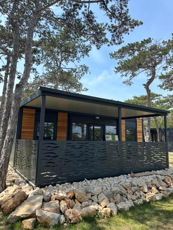 a black house with windows on a pile of rocks at Green Hill Mobile Home in Ražanac