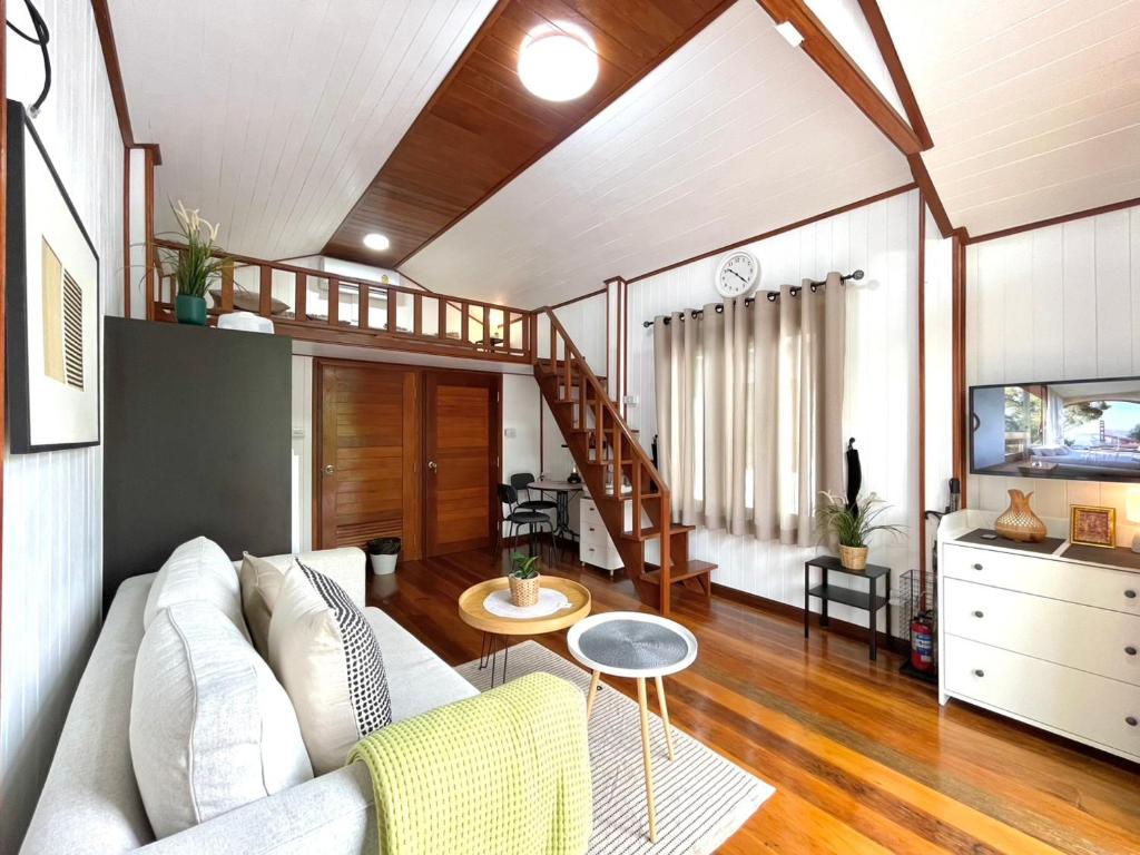 Una sala de estar con un sofá y una escalera. en Anna River Home A3, en Ban Khlong Si