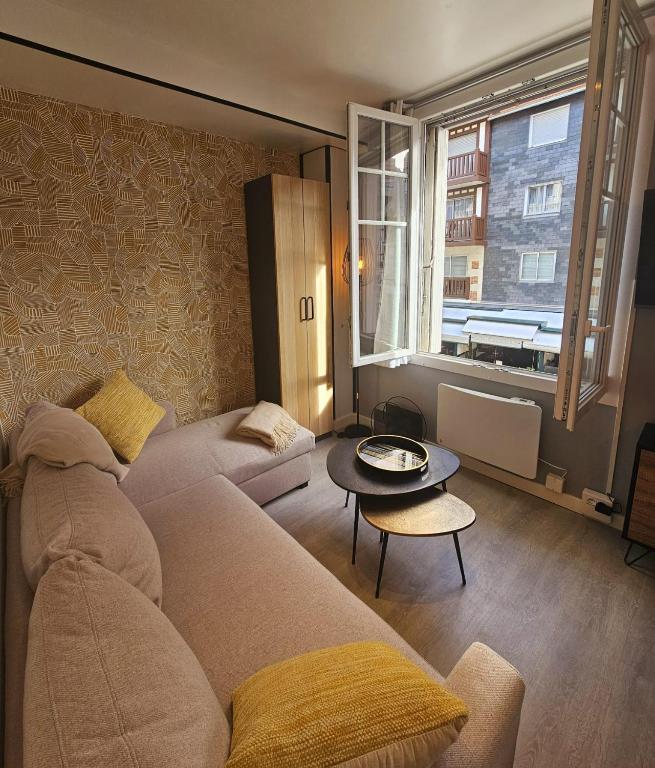 un salon avec un canapé et une table dans l'établissement Le Deauvillais Studio en plein cœur de Deauville, à Deauville