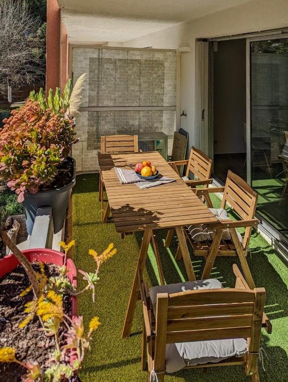 une table et des chaises en bois sur une terrasse dans l'établissement Apartment for 8 guests in Nice city center, à Nice