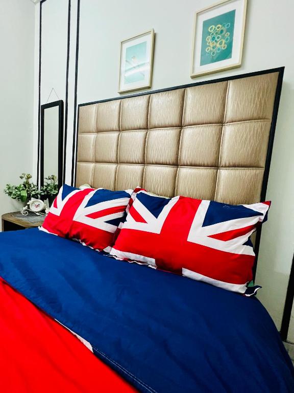 a bed with red white and blue pillows on it at The Pine Lodge- Bukit Tinggi Klang in Klang