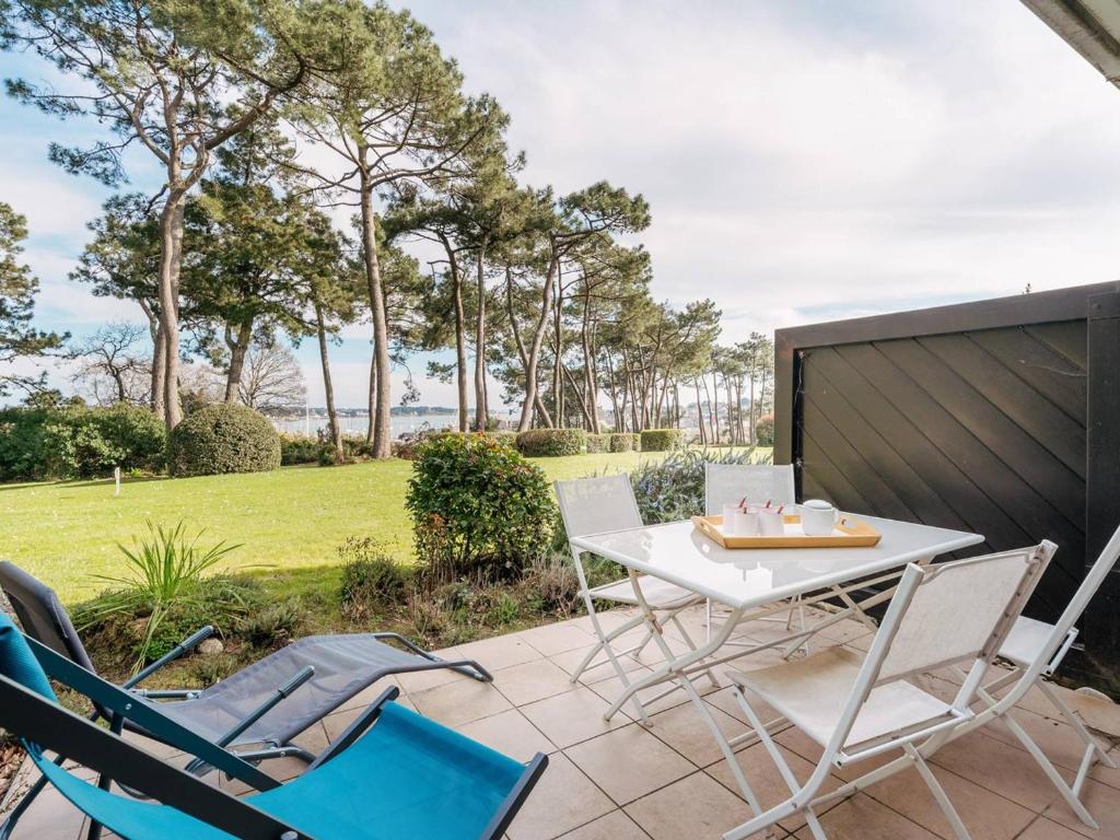 d'une terrasse avec des chaises, une table blanche et des chaises. dans l'établissement Appartement cosy avec parking à La Trinité-sur-Mer - FR-1-477-34, à La Trinité-sur-Mer