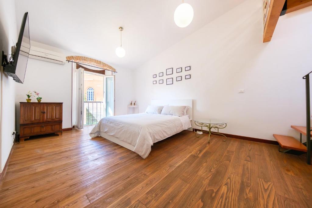 a bedroom with a bed and a wooden floor at Via Fiorenza Apartment in Livorno