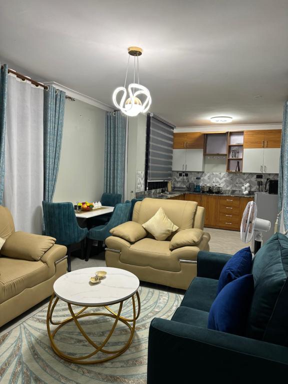 ein Wohnzimmer mit Sofas und einem Tisch in der Unterkunft Supreme Apartments in Kansiri