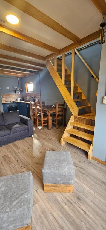 a living room with a couch and a staircase at Cabañas M&R in Puerto Natales