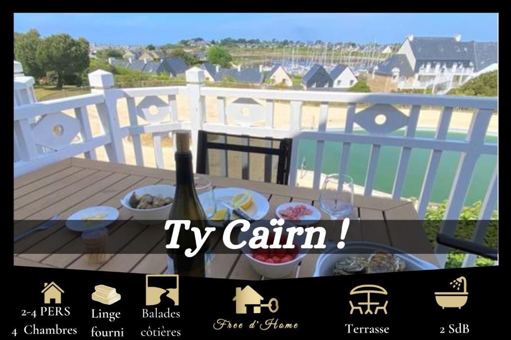 une photo d'une table sur un balcon avec une bouteille de vin dans l'établissement Ty Caïrn - Porte du Crouesty, à Arzon