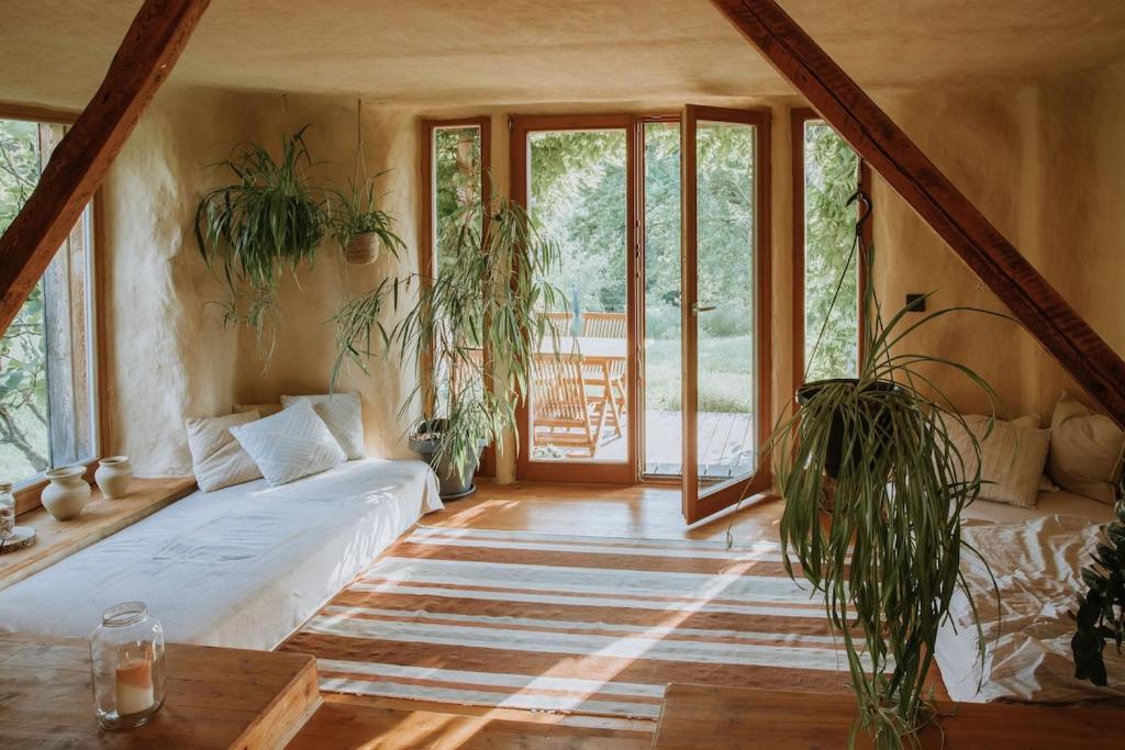 a living room with potted plants and a couch at Private Eco Cottage in Nature in Šulinci