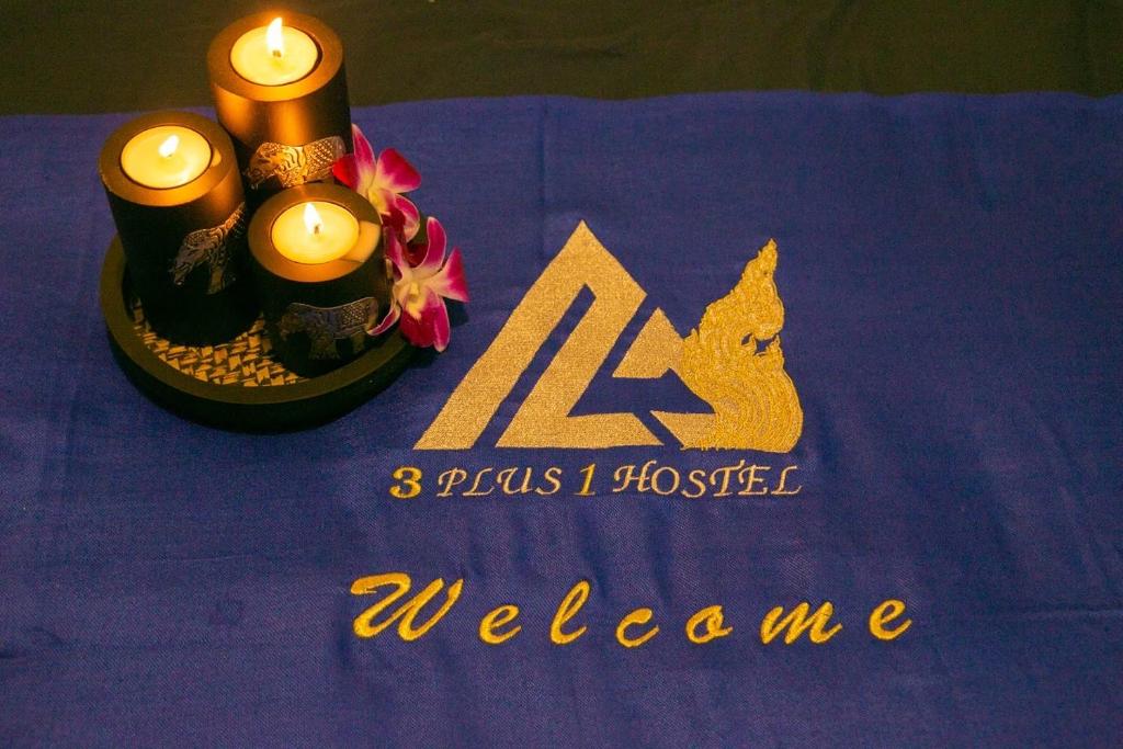 una mesa púrpura con velas y un cartel con un logotipo en 3Plus1 Hostel Patong, en Patong Beach