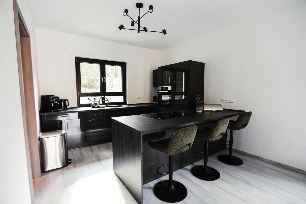 a kitchen with a table and two stools at NEU Inner Light, mit privater Sauna und schnellen Internet, Luxuriöses Ferienhaus im Harz in Altenau
