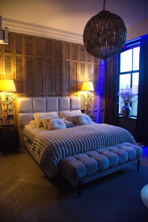 a large bed in a room with two lamps and a window at Roomz B&B in Kloosterzande