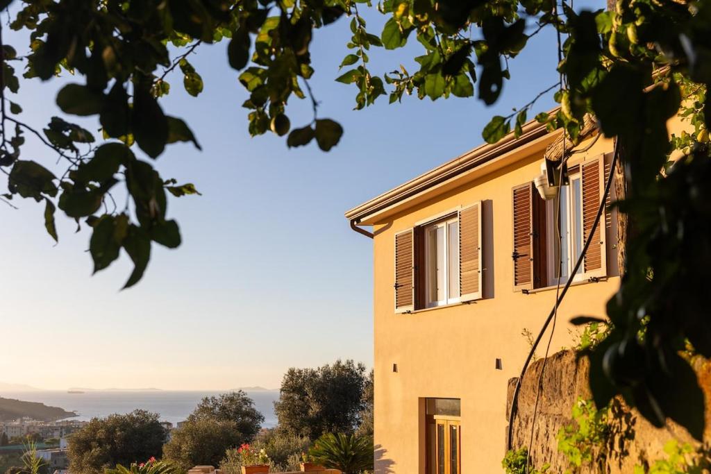 a yellow house with shutters on the window at Lemon Flats Sorrento 2 in Sorrento