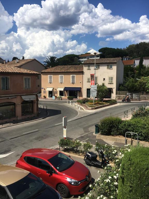 une voiture rouge garée sur un parking dans une rue dans l'établissement Appartement Place des Lices, Saint-Tropez, à Saint-Tropez