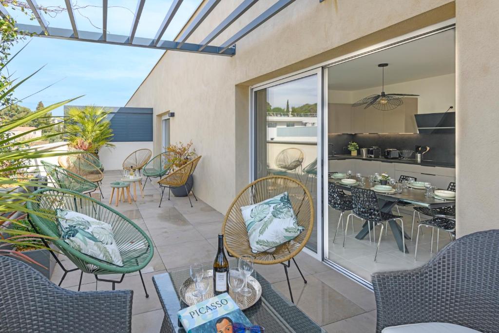 - une terrasse avec des chaises et une table avec des bouteilles de vin dans l'établissement Le Joyau Nîmois - Grande terrasse avec parking, à Nîmes