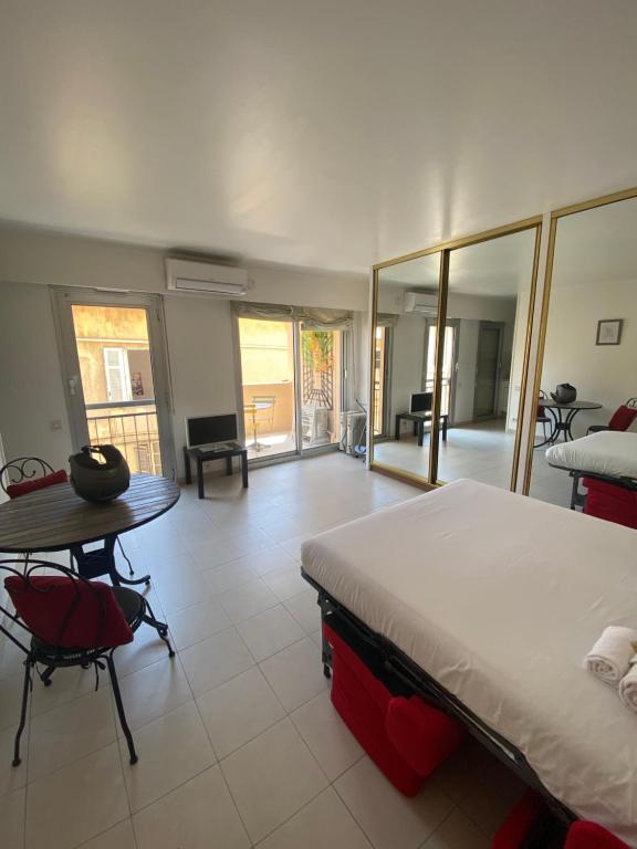 une chambre avec un lit, une table et des chaises dans l'établissement Studio à deux pas du Palais des Festivals, à Cannes