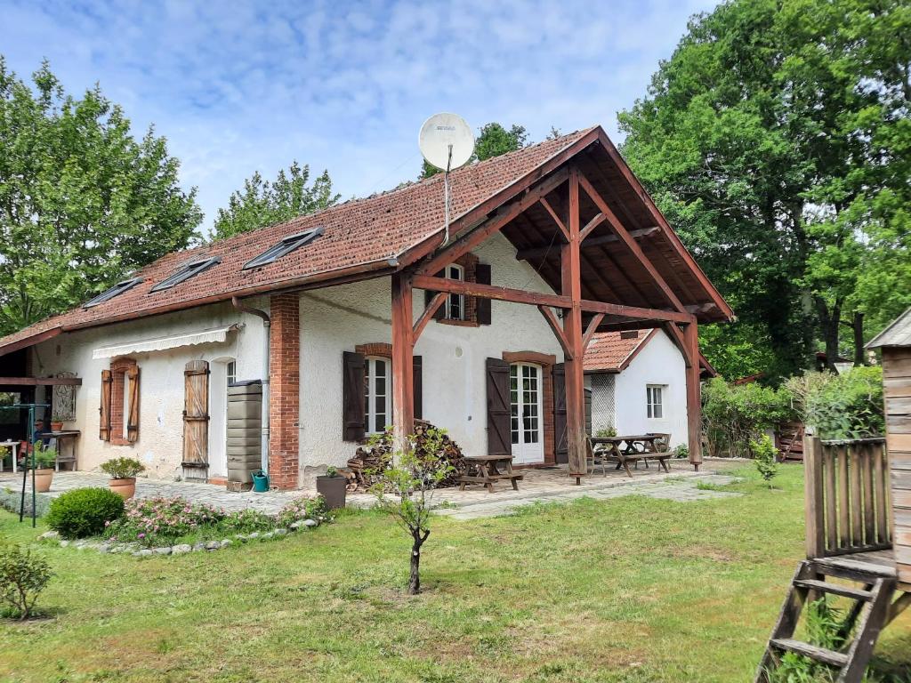 a small white house with a wooden roof at La Bastide in Saint-Vincent-de-Tyrosse