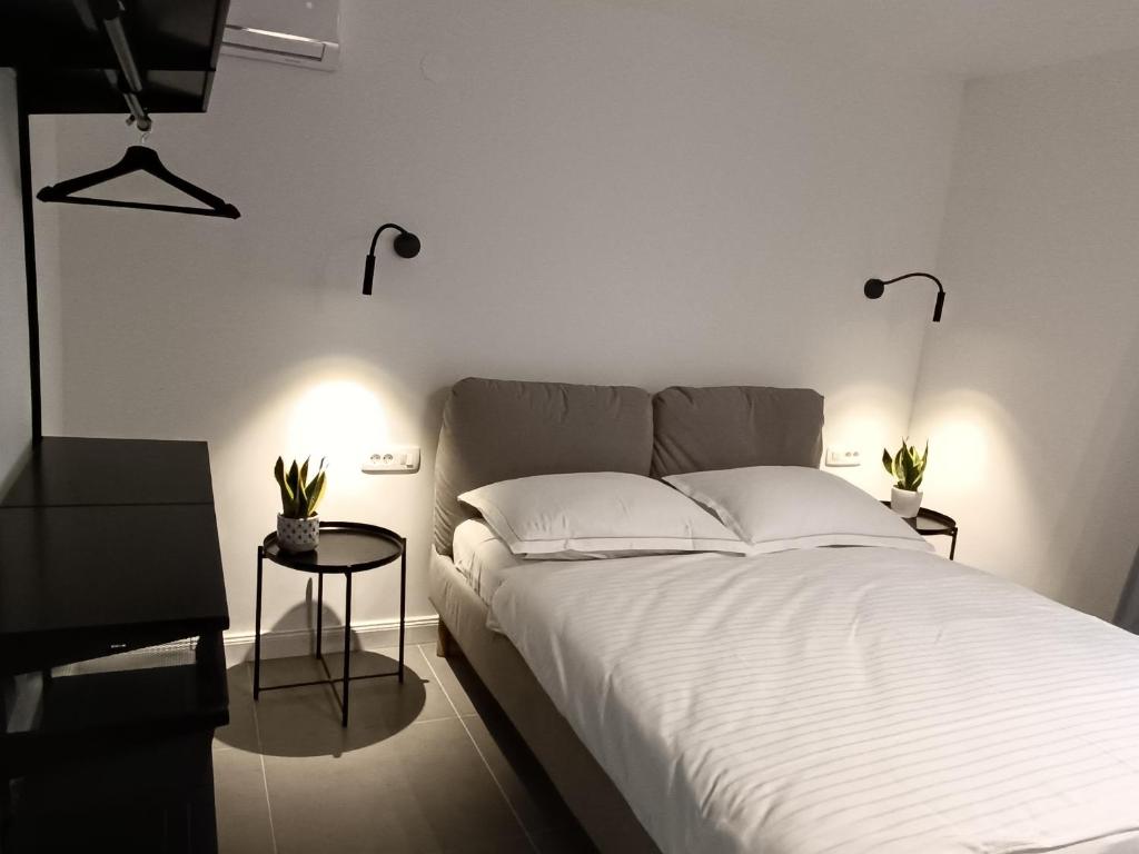 a bedroom with a large white bed with two lamps at Sun-up in Rogoznica