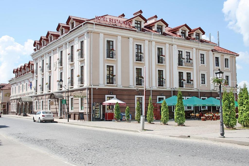 a large white building on the side of a street at Optima Collection Kamianets-Podilskyi in Kamianets-Podilskyi