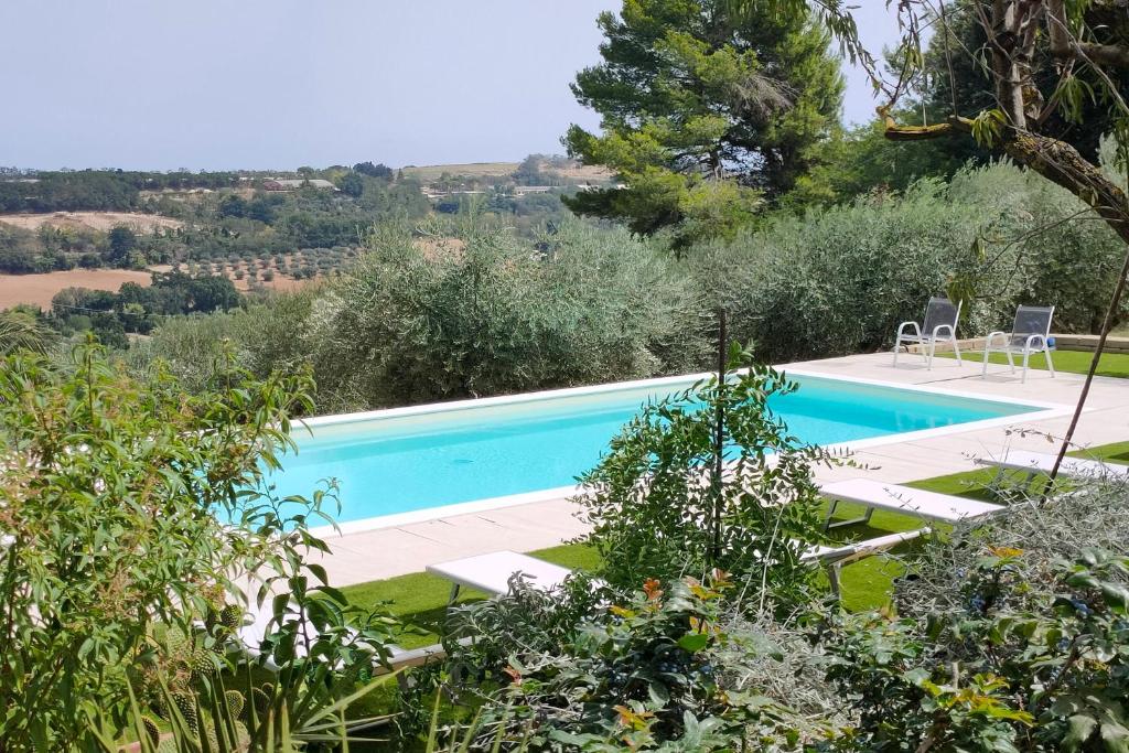 une piscine au milieu d'un jardin dans l'établissement Villa Poggio Bettino by MMega, à Civitanova Marche