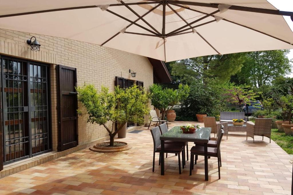 un patio avec un parasol, une table et des chaises dans l'établissement Villa Poggio Bettino by MMega, à Civitanova Marche
