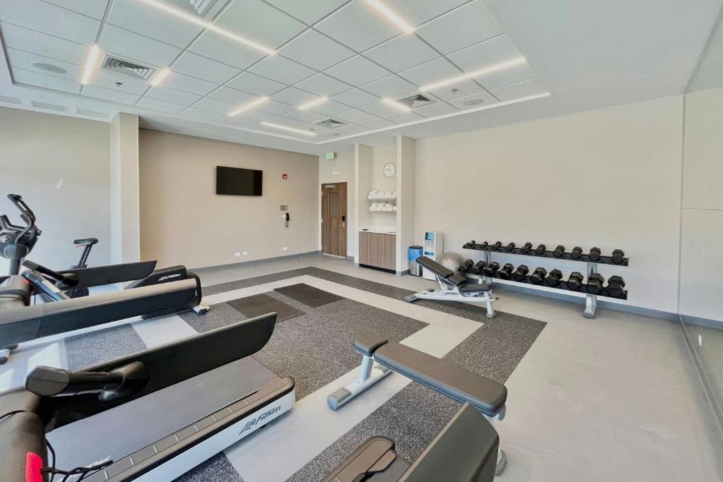 a gym with rows of exercise equipment and a flat screen tv at Fairfield by Marriott San Jose Airport Alajuela in Alajuela City