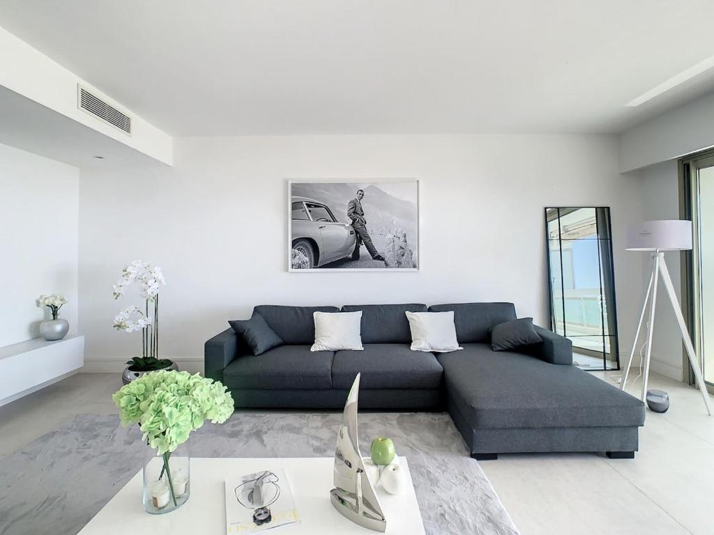 - un salon blanc avec un canapé bleu dans l'établissement Appartement Vue mer, à Vallauris