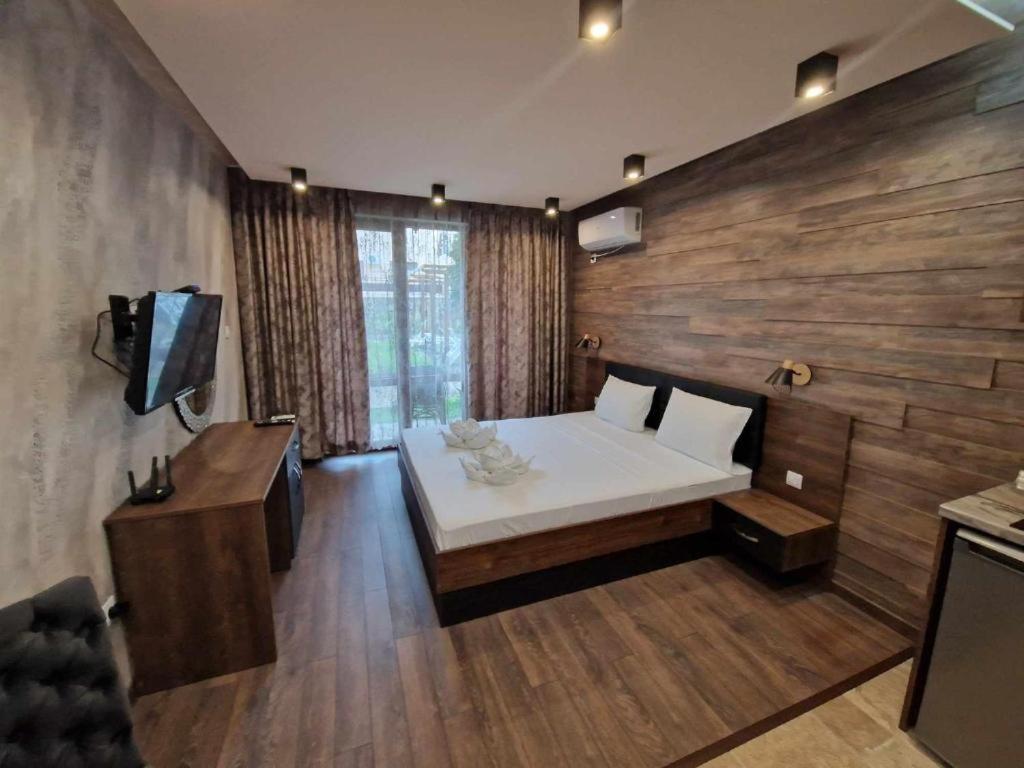 Un dormitorio con una cama blanca y una pared de madera. en MitProt Panorama Bay 2 Luks Studio 29, en Sveti Vlas