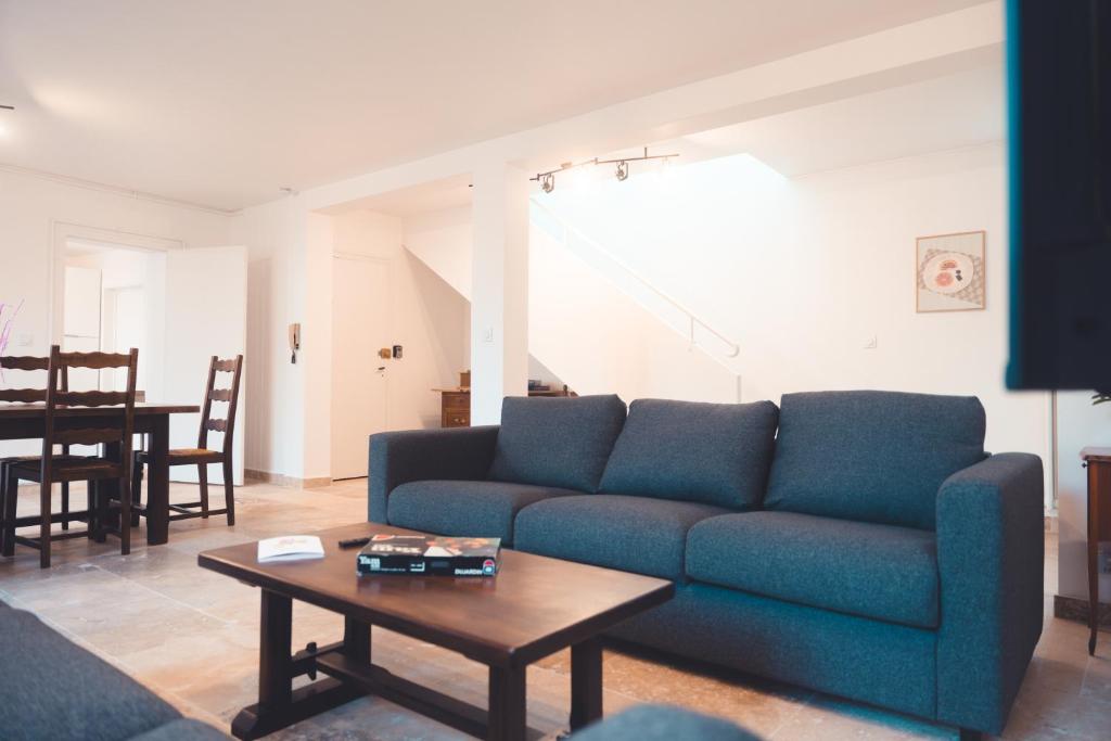 un salon avec un canapé bleu et une table dans l'établissement L'Unique- Maison de famille en Plein Centre-Ville, à Tours