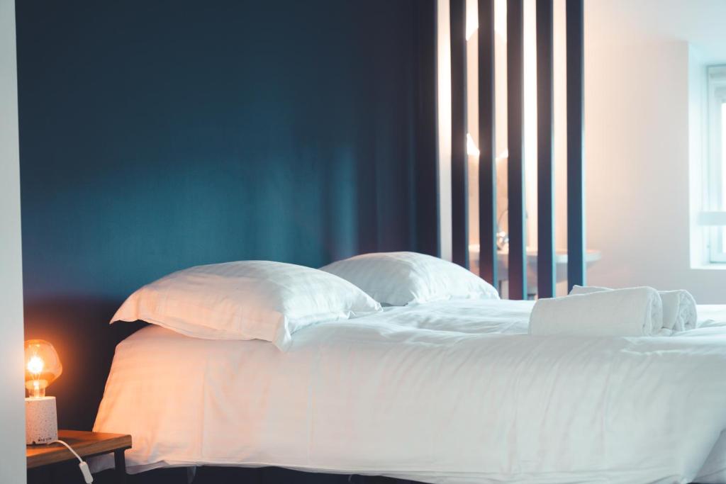 a bed with white sheets and pillows in a bedroom at L'Unique- Maison de famille en Plein Centre-Ville in Tours