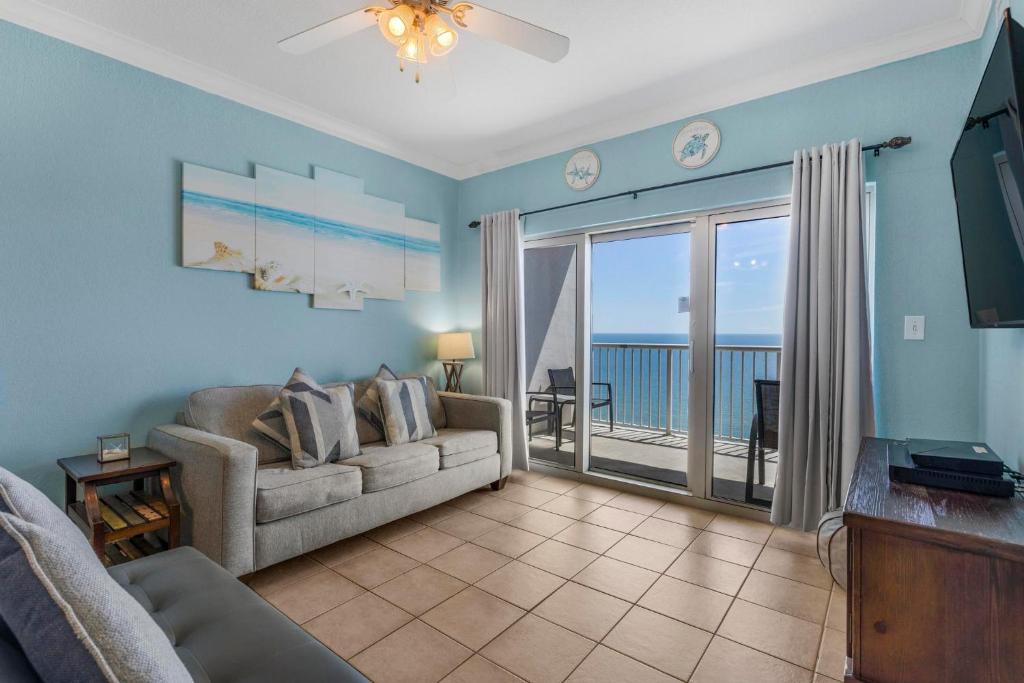 a living room with a couch and a sliding glass door at Crystal Tower 1906 by Vacation Homes Collection in Gulf Shores
