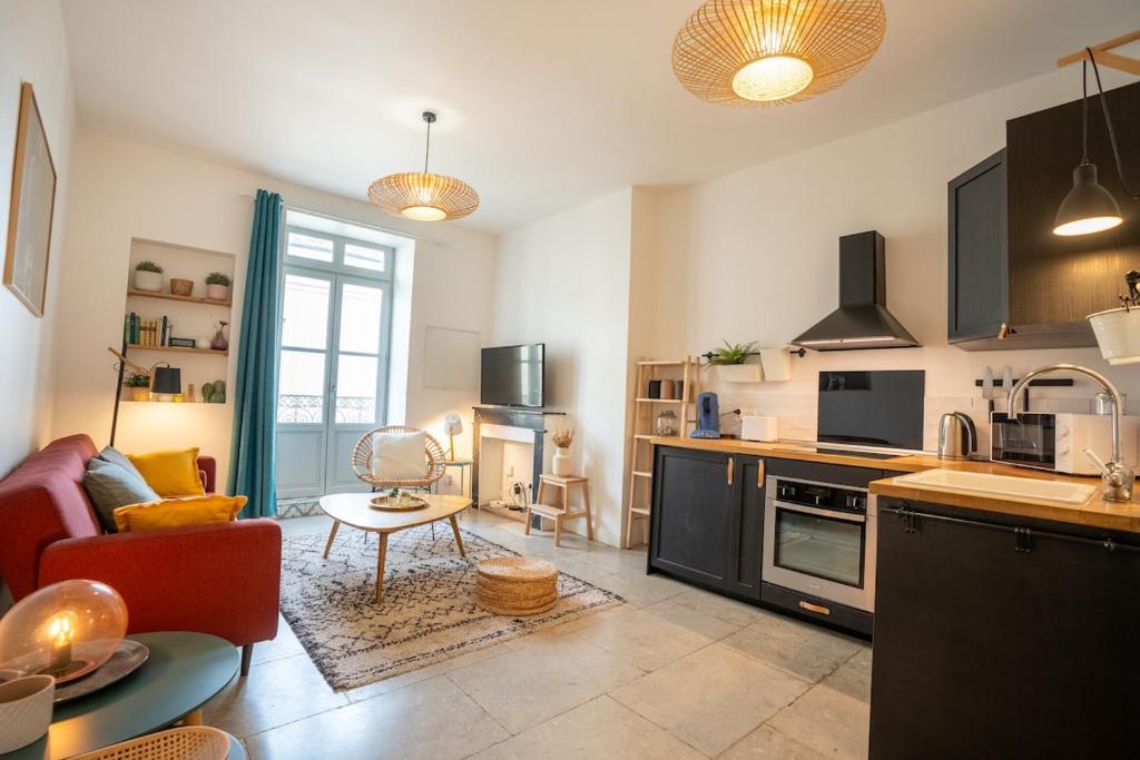 une cuisine et un salon avec un canapé et une table dans l'établissement Purple T2 centre ville avec clim, à Montpellier