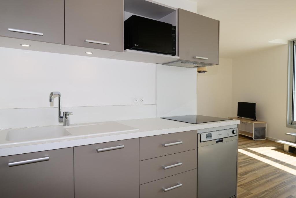 Kuchyň nebo kuchyňský kout v ubytování MY Hôtel Résidences - La Grande-Motte