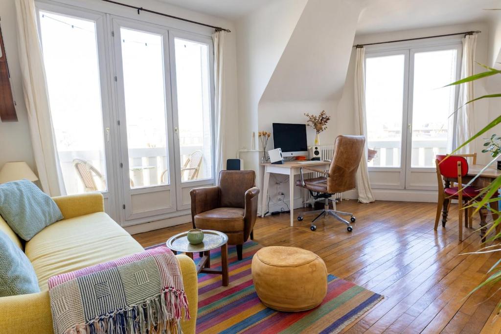 - un salon avec un canapé et un bureau avec un ordinateur dans l'établissement Two rooms with view near canal, à Paris