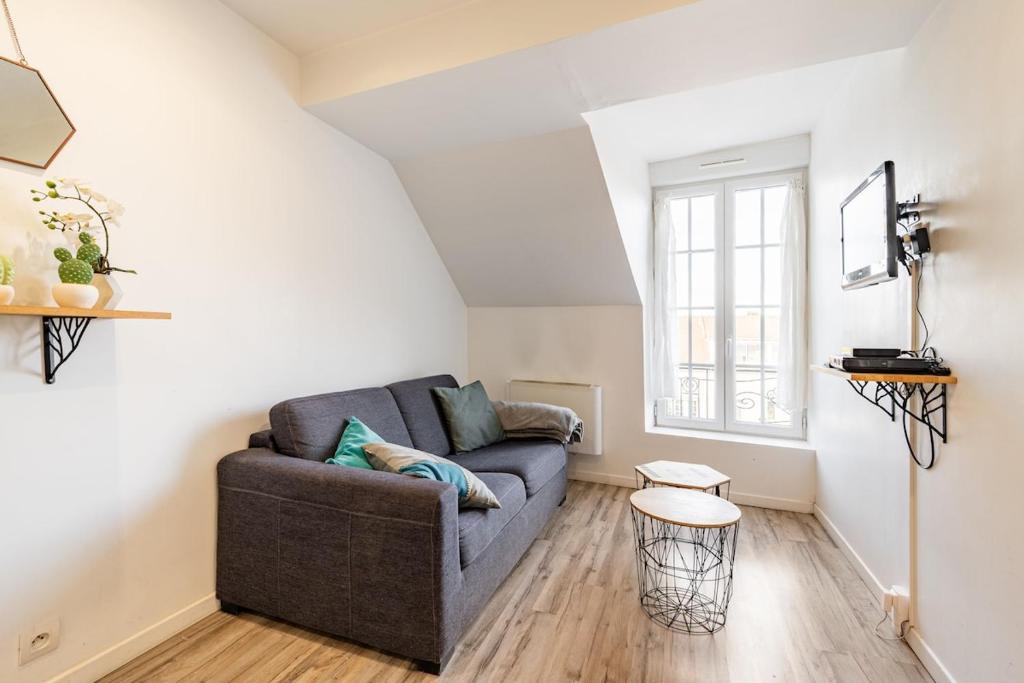 un salon avec un canapé et une table dans l'établissement Charmant appartement proche commodités et Disney !, à Montévrain