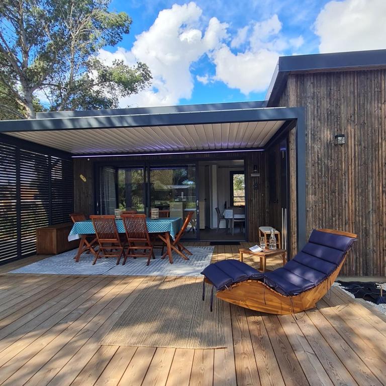 une terrasse avec une table et des chaises sur une maison dans l'établissement Chalet de Prestige à Agde, Résidence privée avec Spa et Piscines proche plages, à Agde