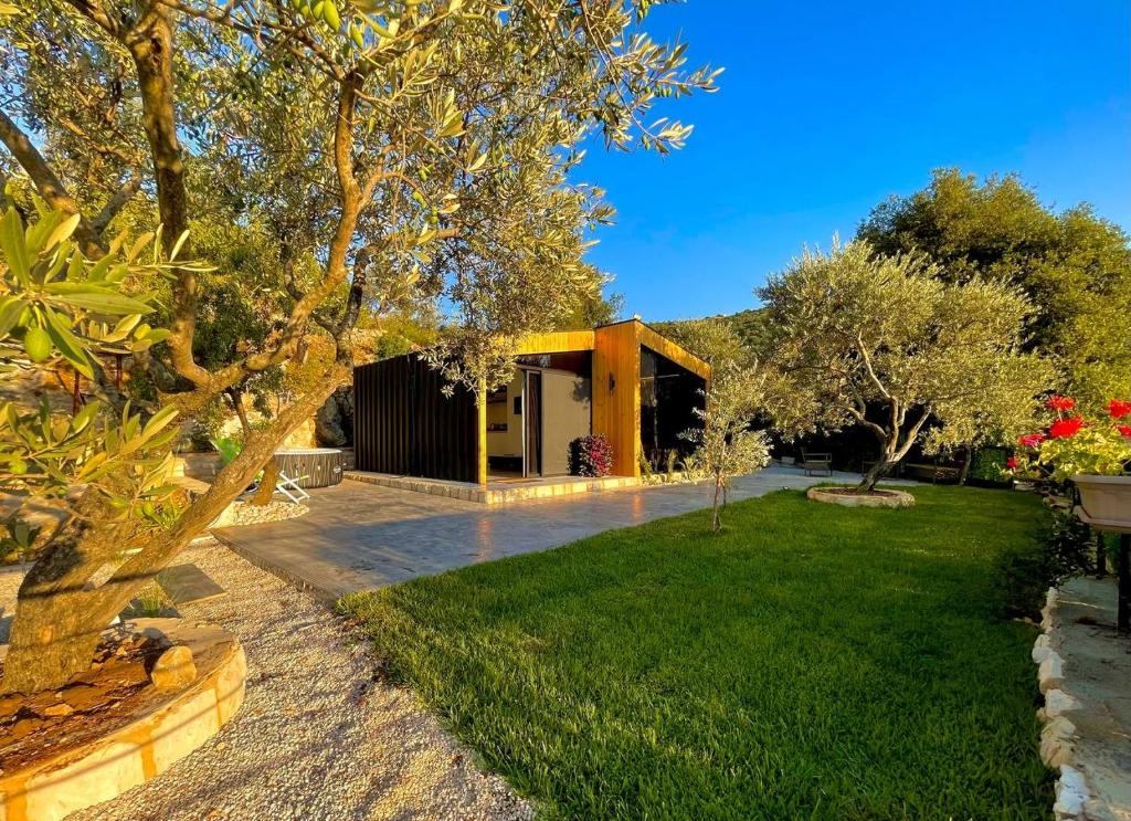 una casa con un cortile verde con un edificio di Mit Warde Cabin a Batroûn