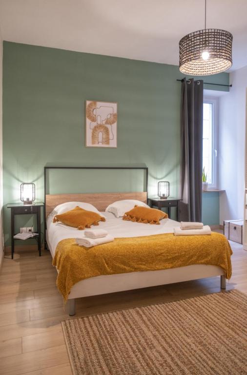 une chambre avec un grand lit et un lustre dans l'établissement L'indus - Centre - Proche gare, à Saverne