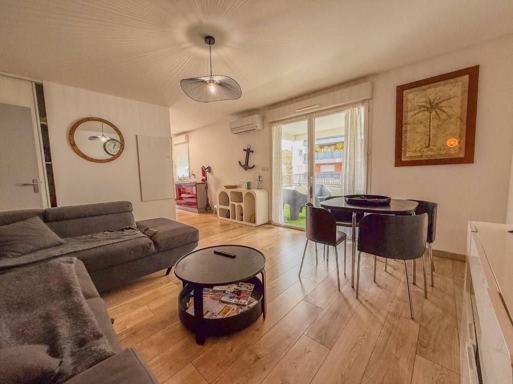 un salon avec un canapé et une table dans l'établissement T3 dans Résidence avec Piscine , plage à pieds et proche commerces, au Lavandou