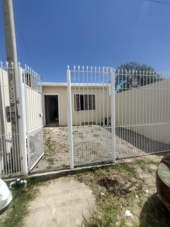 a white fence in front of a house at Casa praia in Pelotas